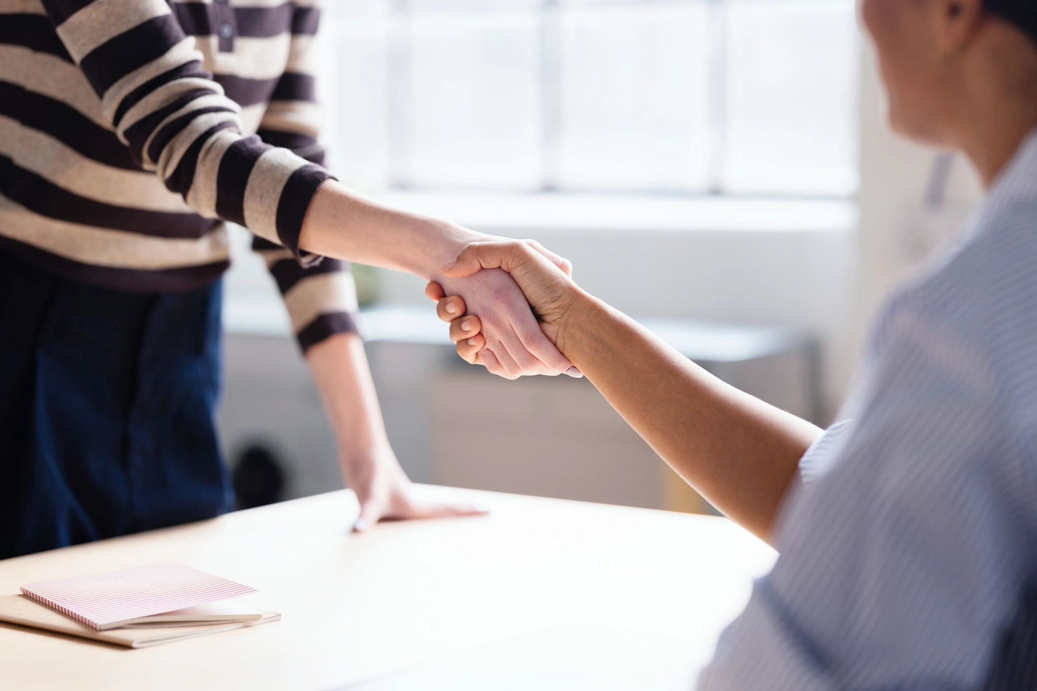 Professionals shaking hands in an office after reaching agreement